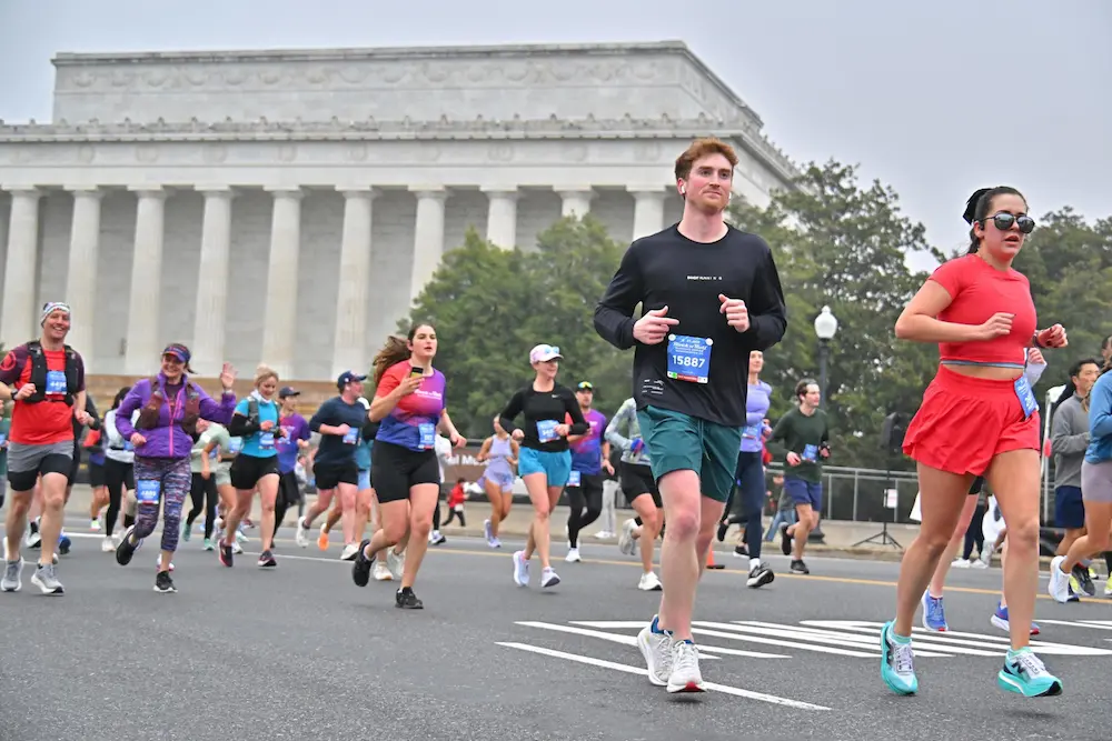 Runners participating in marathon near historic building.