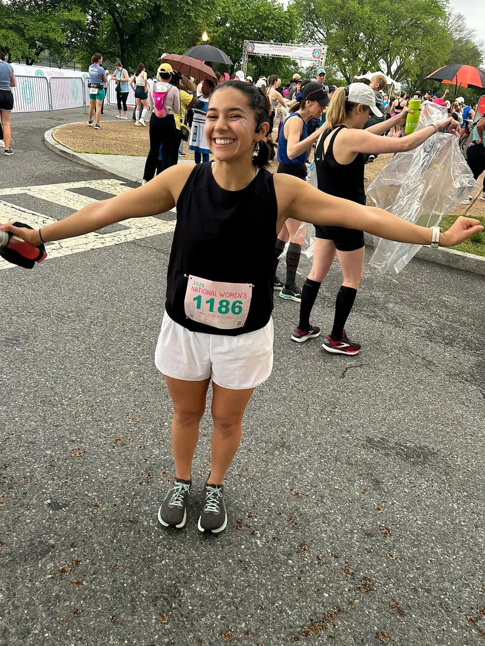 Happy runner at race event, arms outstretched.