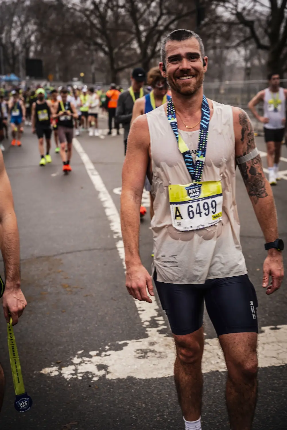 Marathon runner smiling at finish line in NYC.