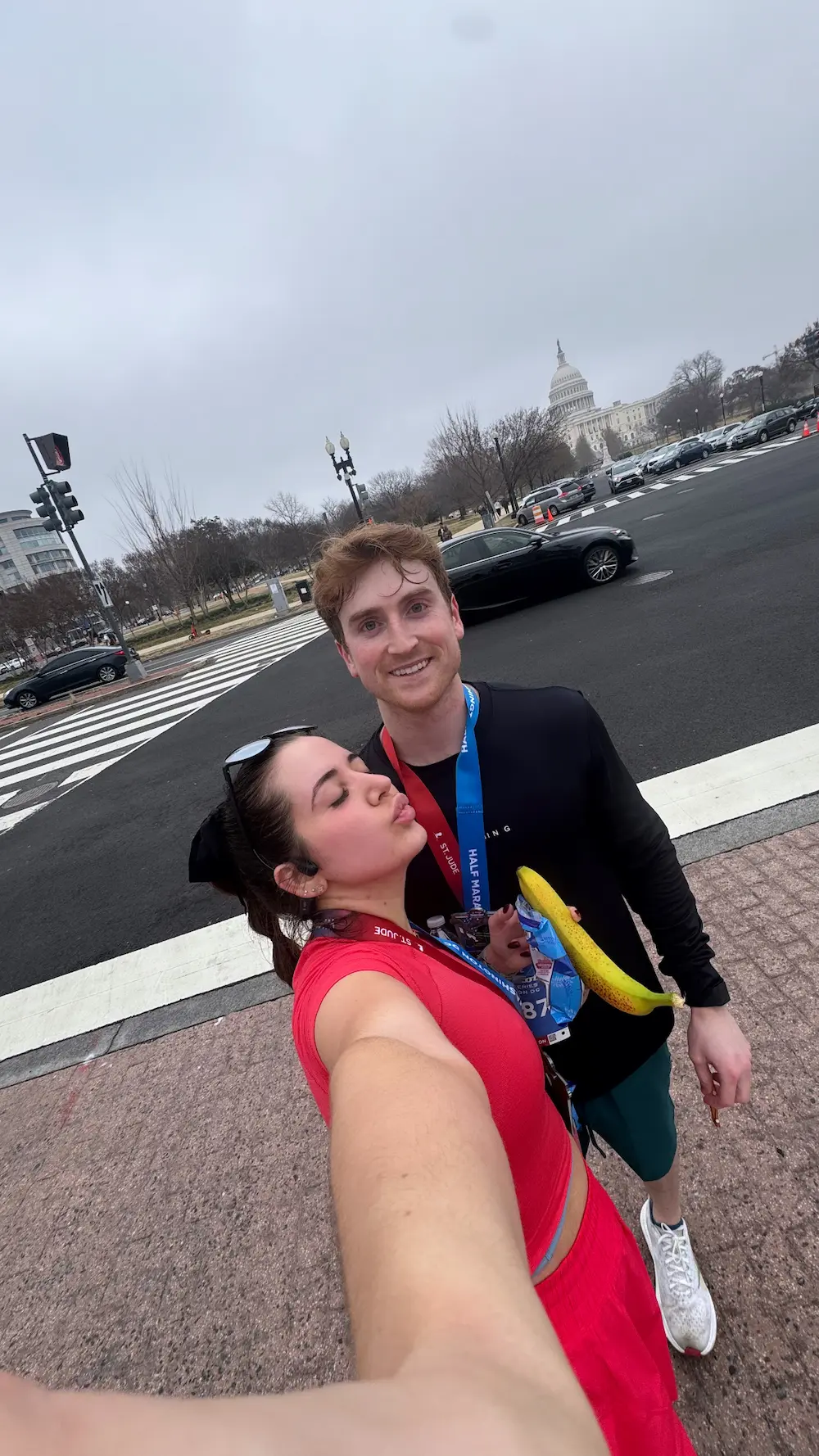 Two runners with medals near the Capitol building.
