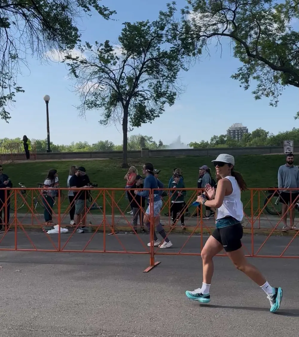 Woman running in park during race event.
