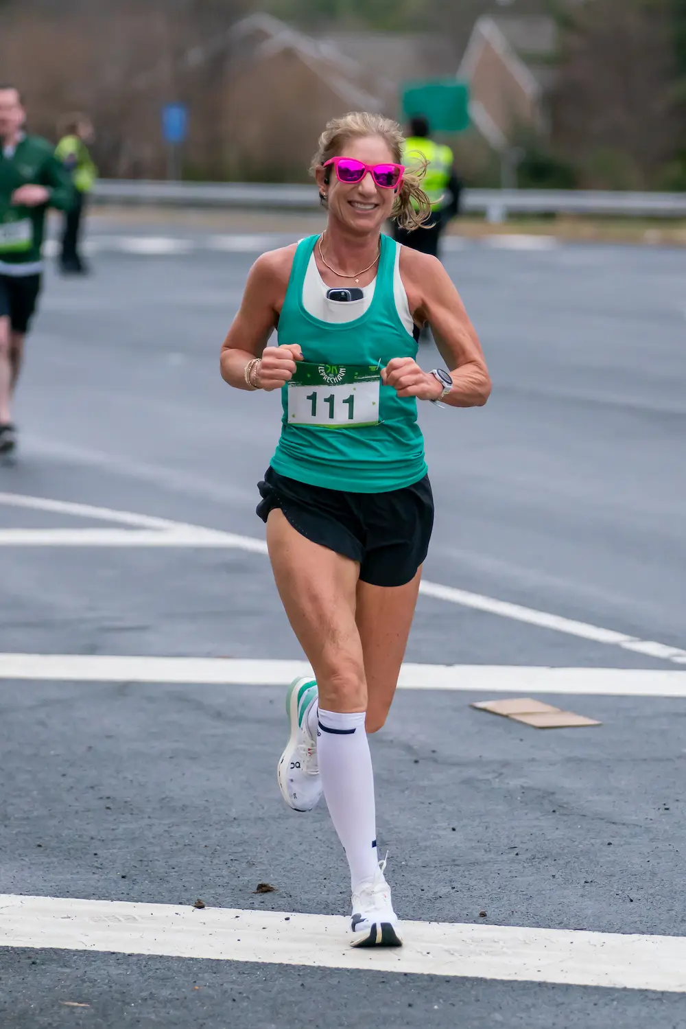 Smiling runner in green jersey during marathon.