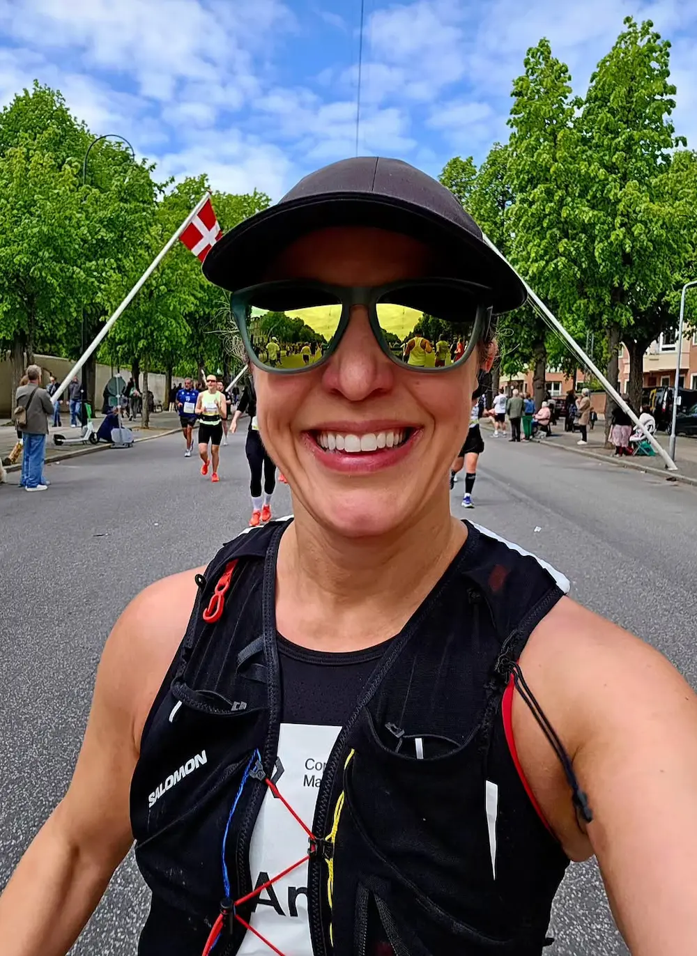 Smiling runner at outdoor marathon event.