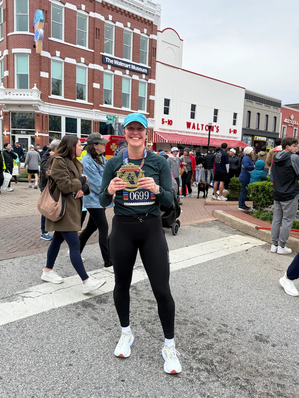 Runner holding medal near Walton's museum entrance.