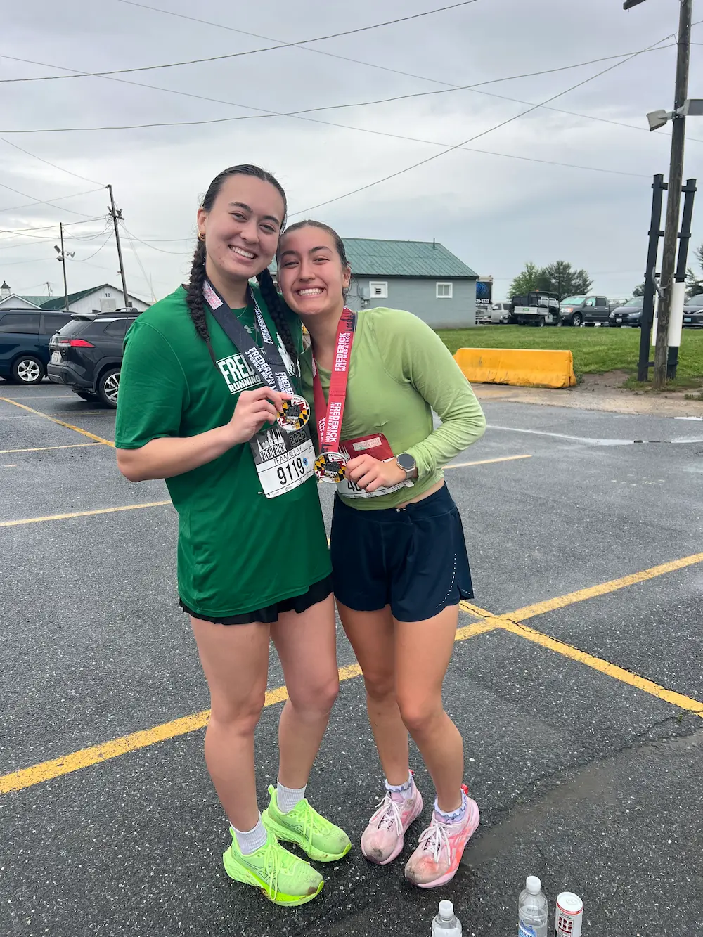 Two runners smiling after a race with medals.
