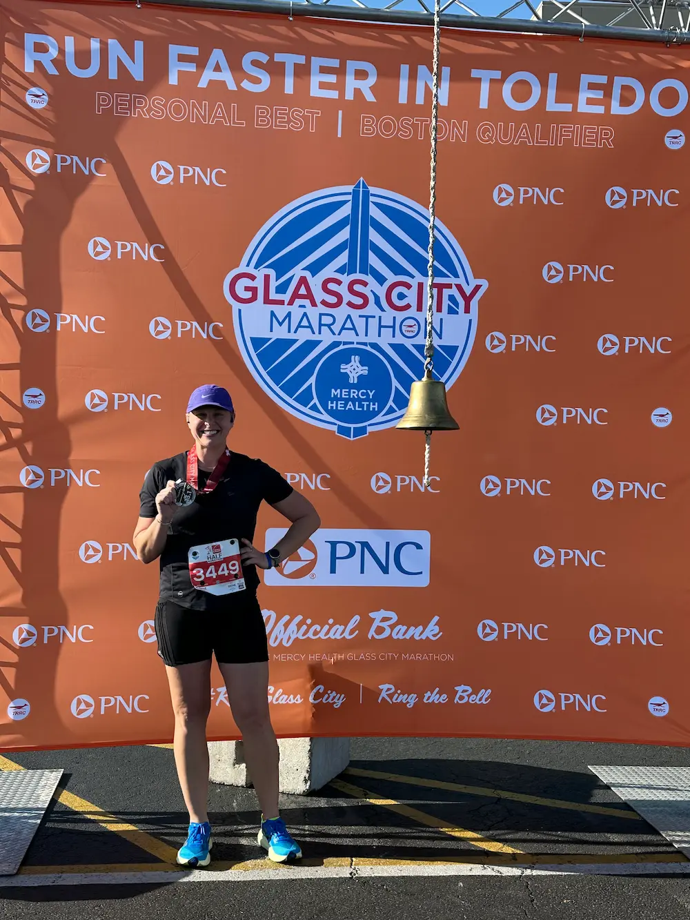Runner poses at Glass City Marathon finish line.