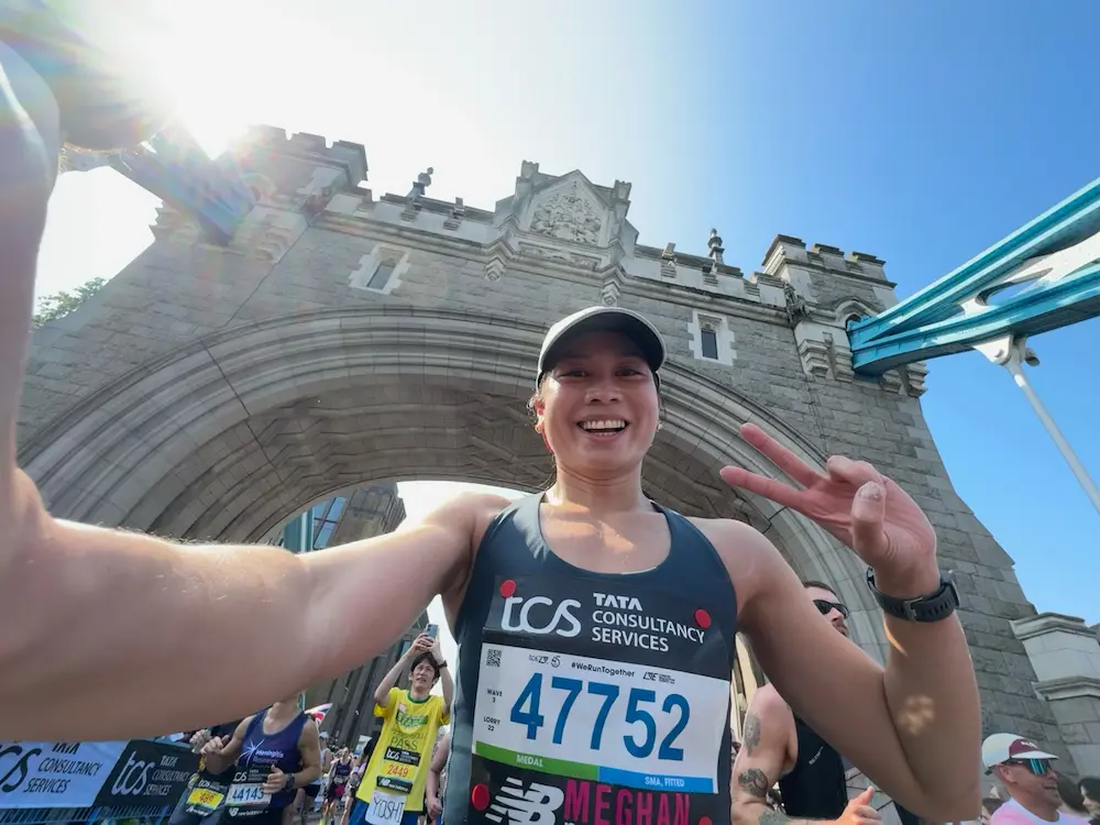 Runner smiling in front of race archway.
