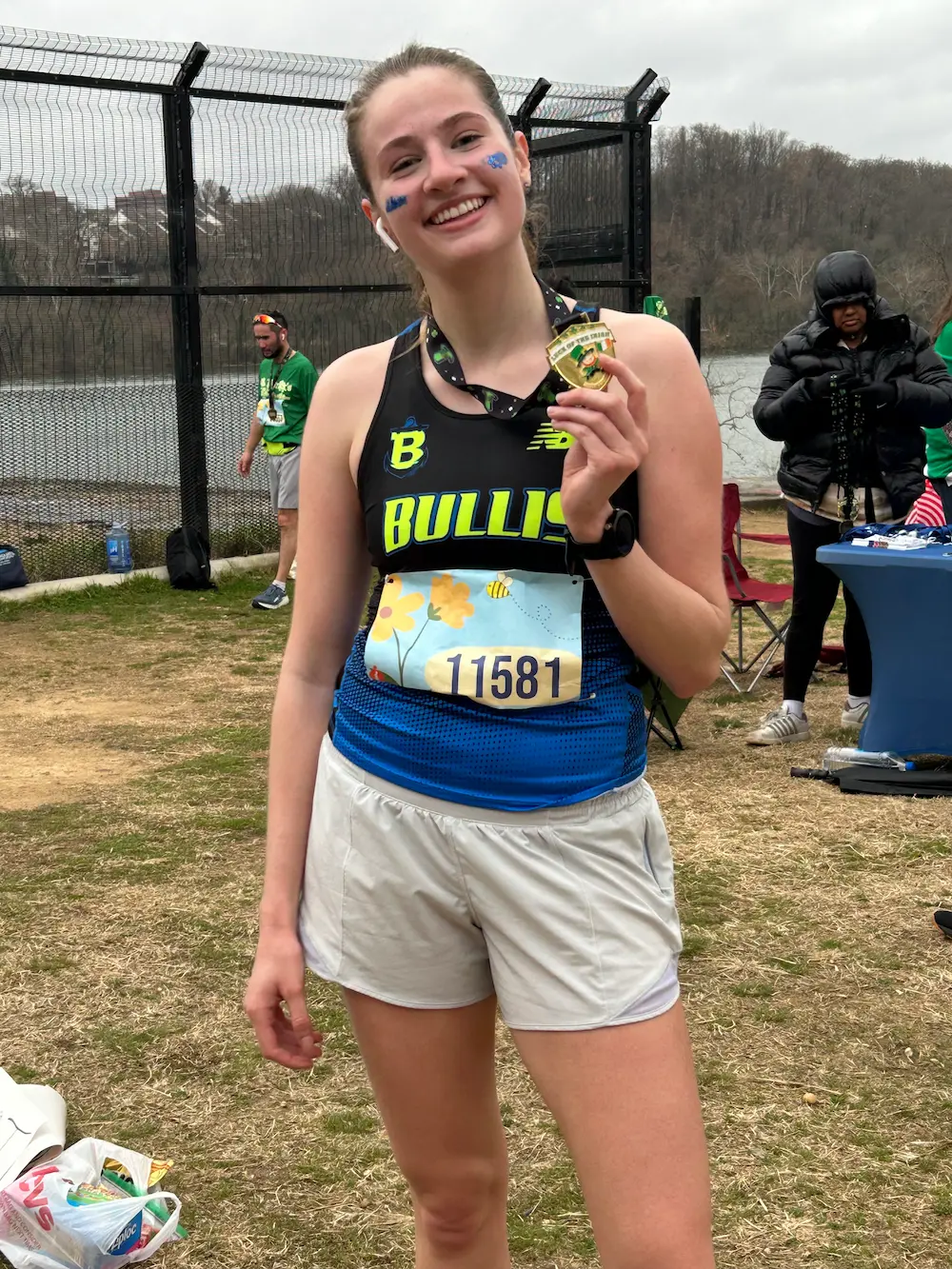 Smiling runner shows medal after race victory.