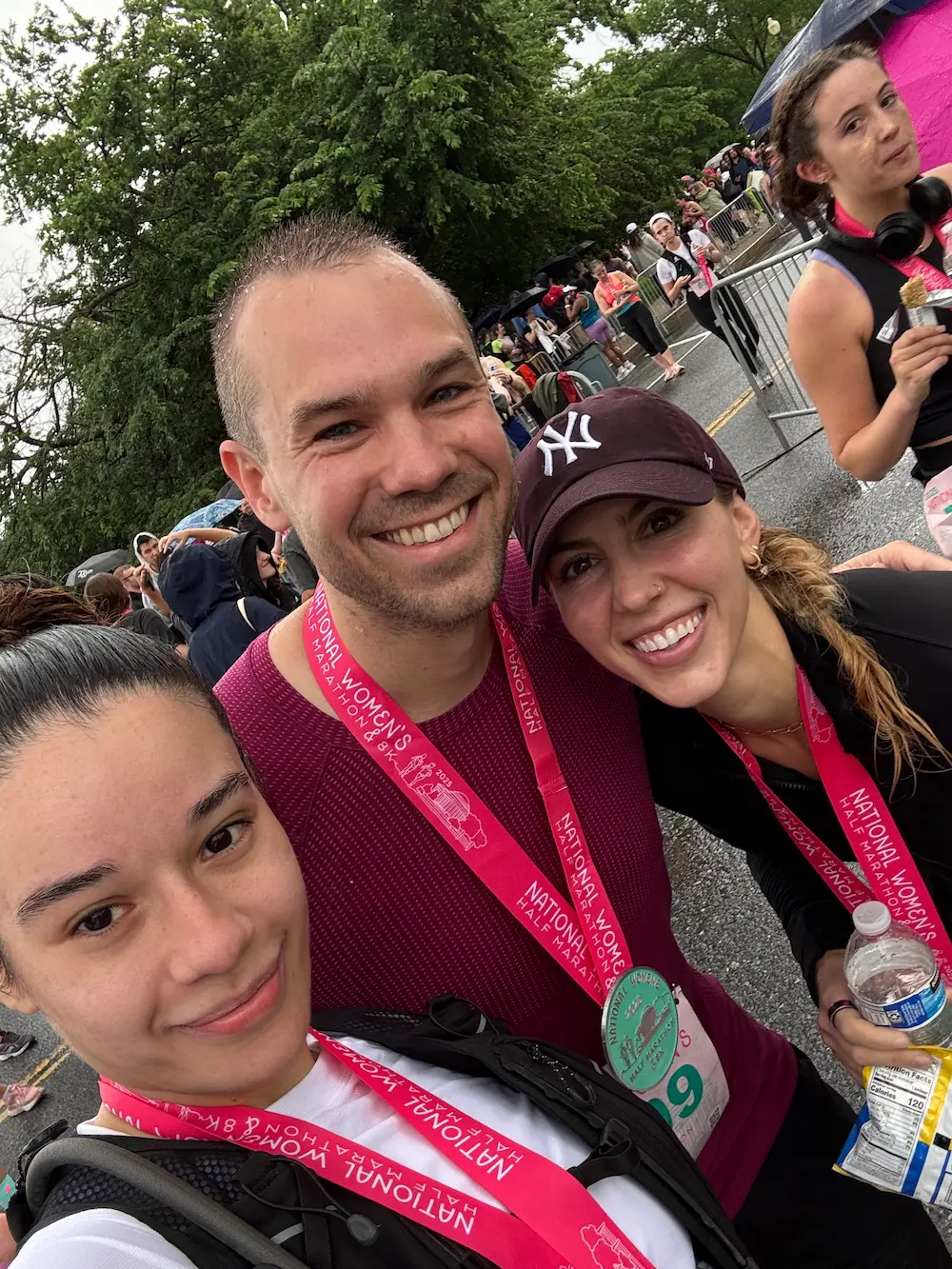Smiling runners wearing medals after race event.
