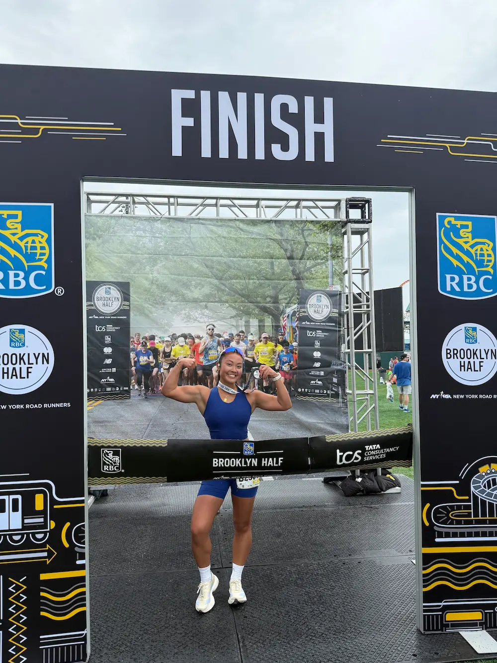 Runner celebrates crossing Brooklyn Half Marathon finish line.