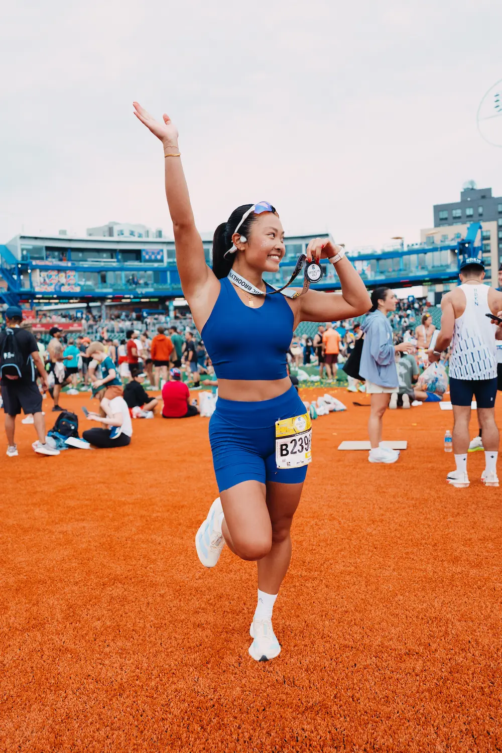 Woman celebrates marathon finish with medal.
