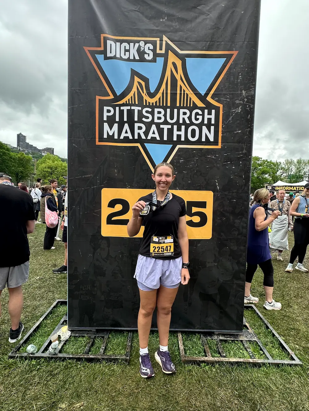 Runner celebrates finishing Pittsburgh Marathon with medal.
