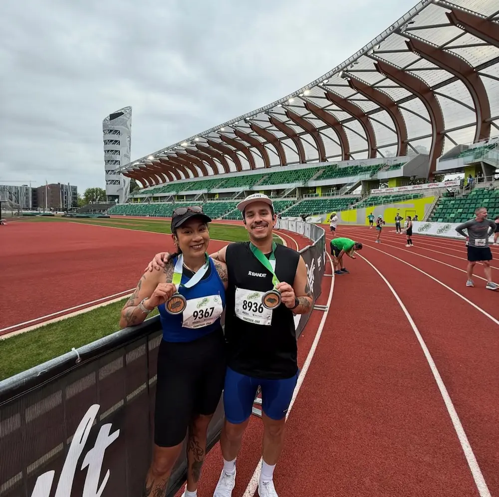 Two runners with medals on track field.