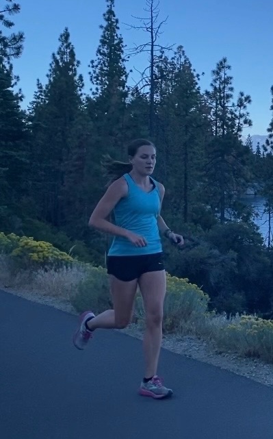Woman jogging on a forest path.