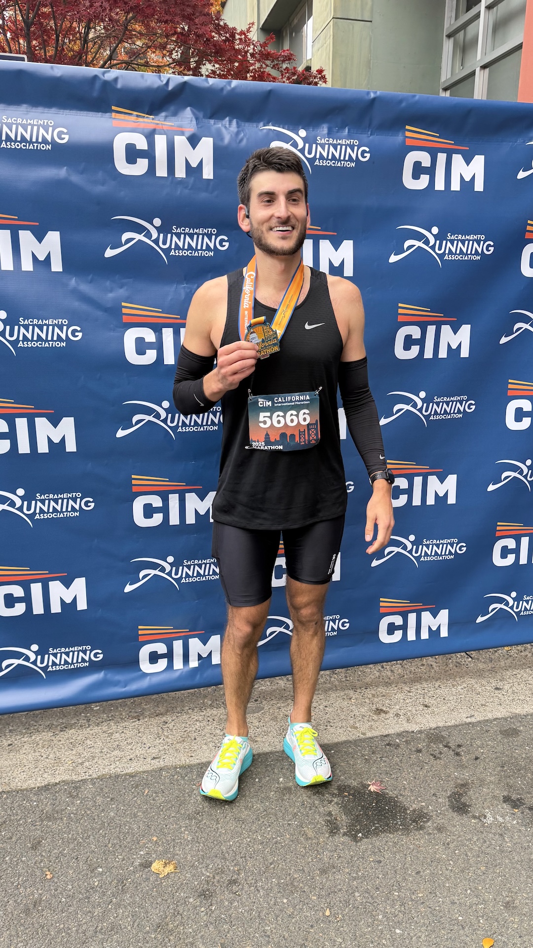 Marathon runner with medal at CIM backdrop