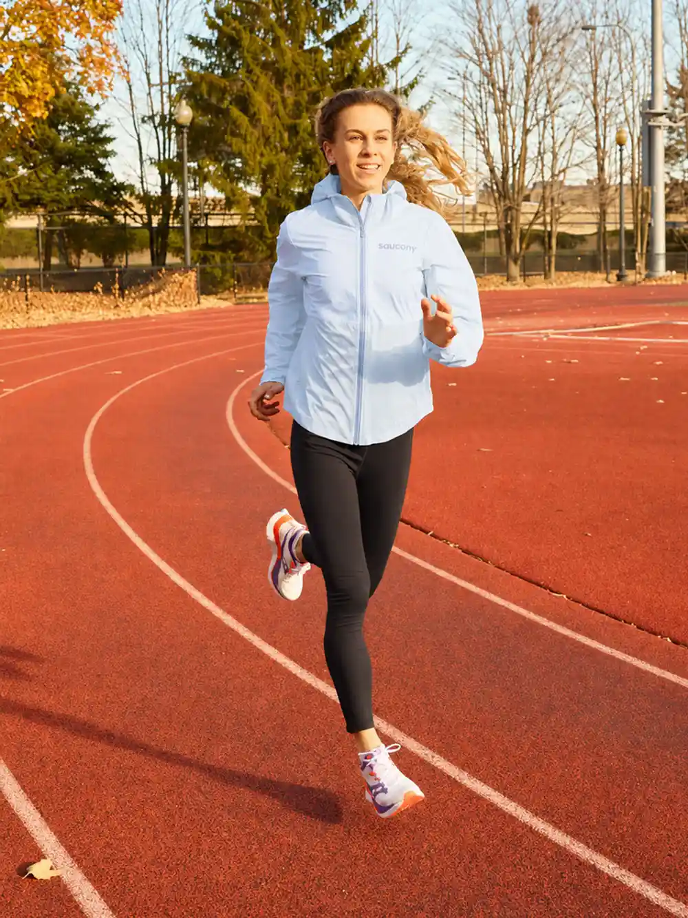 Woman running on outdoor track in autumn