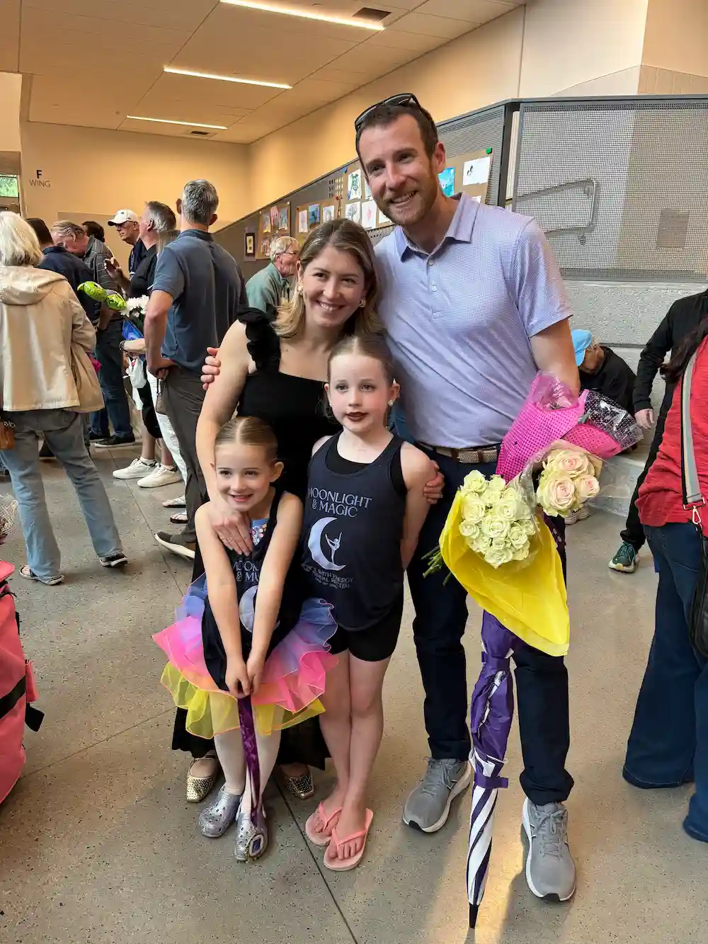 Family celebrates young dancers with bouquets after a performance.